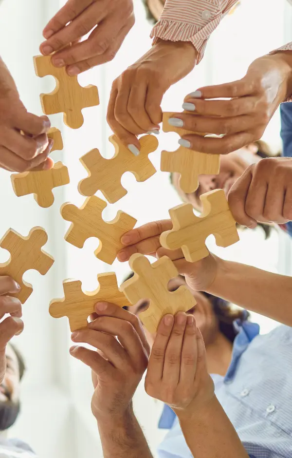 Membres d'une équipe qui assemblent des pièces de puzzle