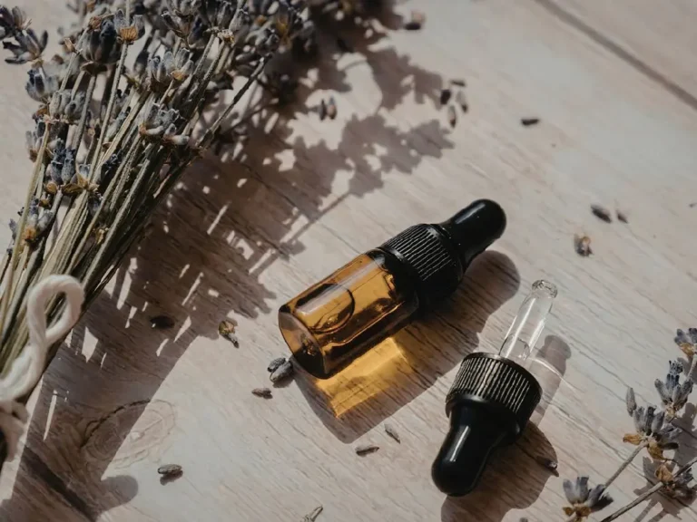 Flacon d'huile essentielle avec un bouquet de lavande à côté